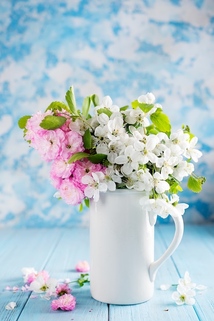 Bouquet de belles fleurs sauvages dans un vase en céramique sur la table dans le fond en bois