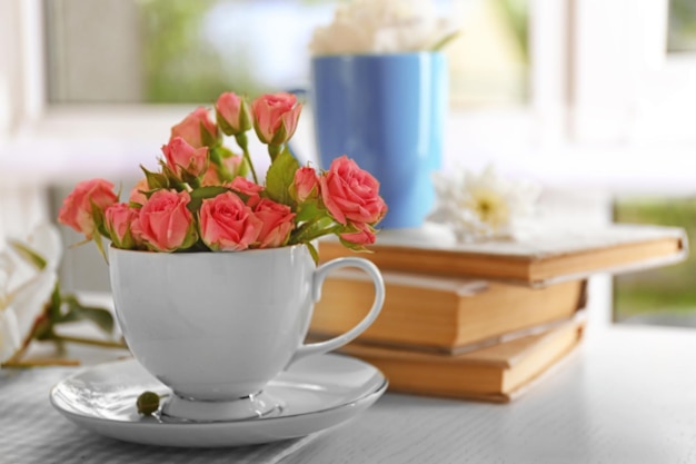 Bouquet de belles roses dans une tasse sur une nappe