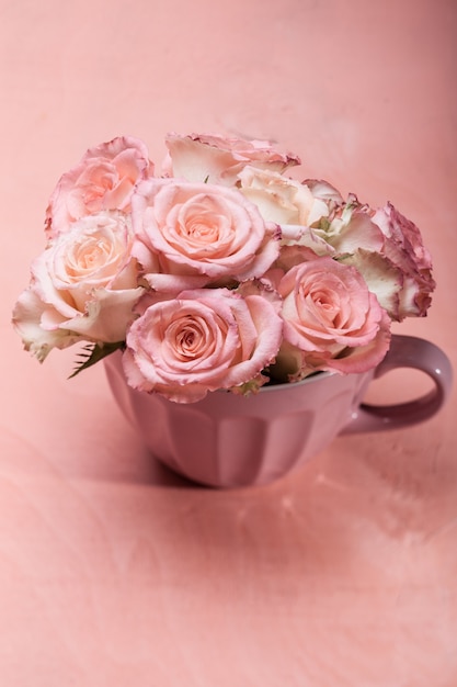 Bouquet de belles roses roses fraîches dans une tasse