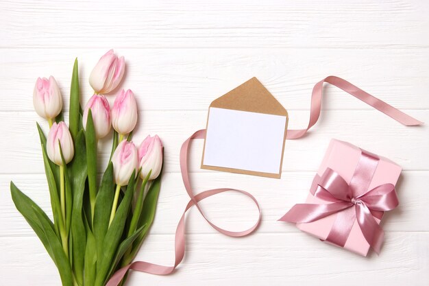 Un bouquet de belles tulipes et un cadeau sur une vue de dessus de fond en bois