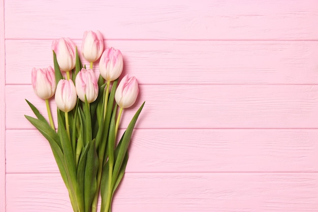 Un bouquet de belles tulipes et un cadeau sur une vue de dessus de fond en bois