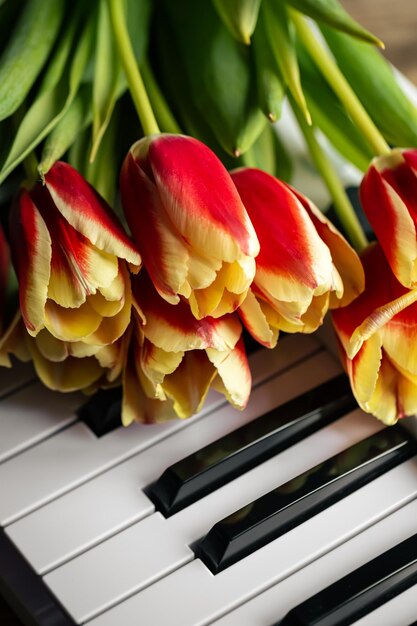 Un bouquet de belles tulipes sur les touches du piano le printemps concept de musique de fond