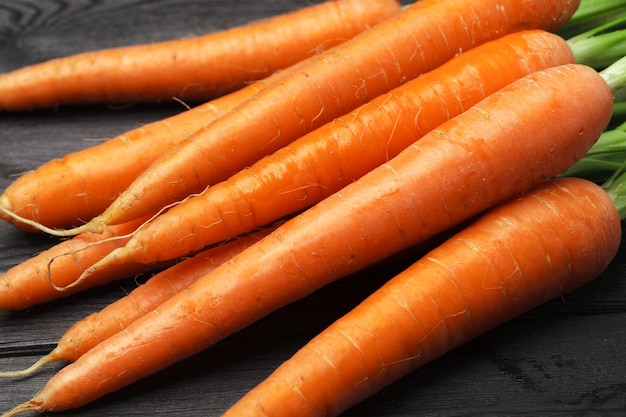 Bouquet de carottes fraîches avec des feuilles vertes sur une table en bois