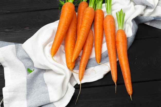 Bouquet de carottes fraîches avec des feuilles vertes sur une table en bois