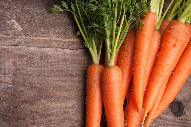 bouquet de carottes fraîches sur fond de bois grungy