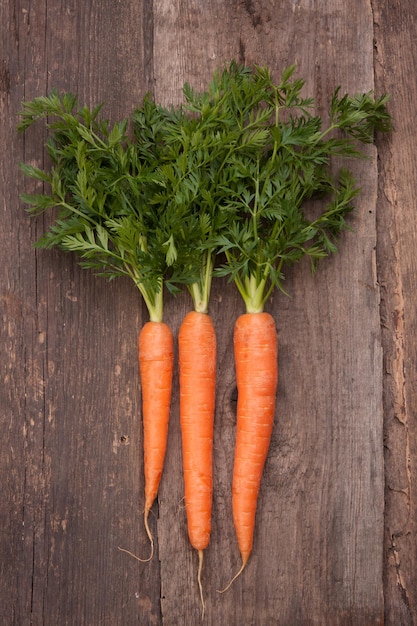 Bouquet de carottes fraîches sur fond de bois grungy