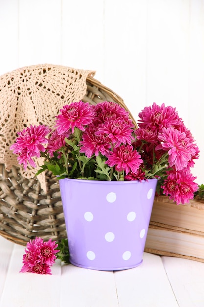 Bouquet de chrysanthème rose dans un seau sur fond de bois blanc