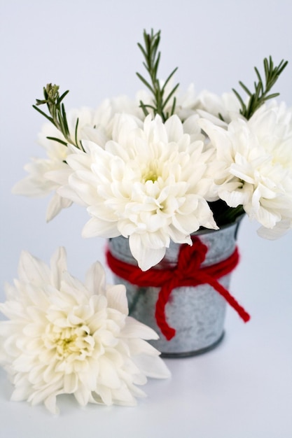un bouquet de chrysanthèmes blancs dans un seau en fer