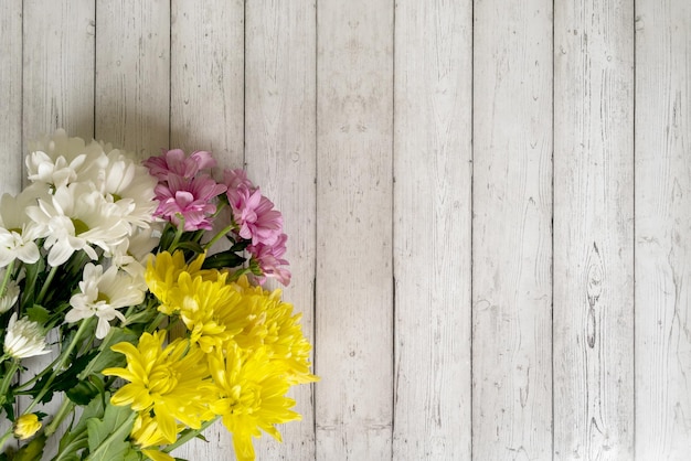 bouquet de chrysanthèmes colorés sur un fond en bois