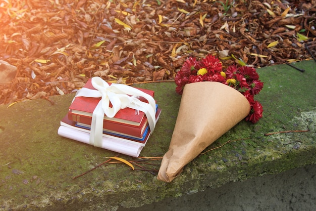 Bouquet de chrysanthèmes et une pile de livres