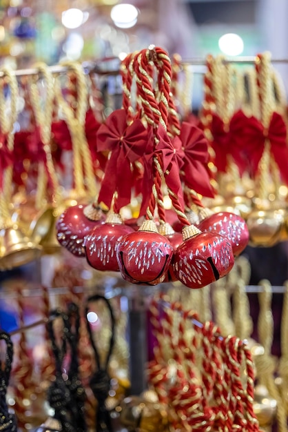 Un bouquet de cloches est suspendu à un rack avec le mot noël dessus.