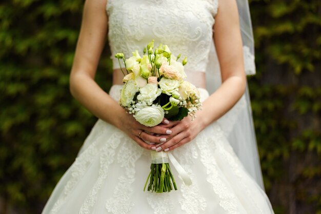 Bouquet dans les mains de la mariée