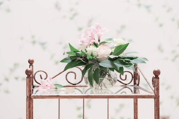 Bouquet délicat dans un vase en verre à l'intérieur vintage