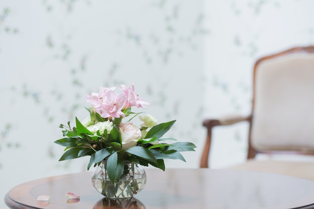 Bouquet délicat dans un vase en verre à l'intérieur vintage