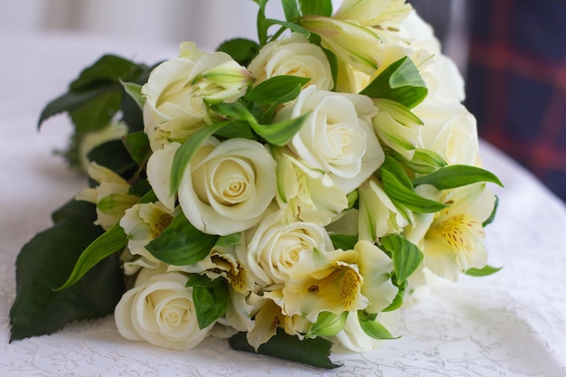 Photo bouquet délicat festif avec des roses légères sur la table sur fond de verres en verre