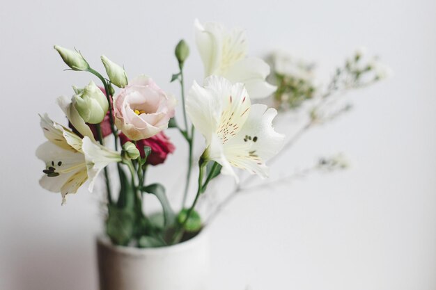 Bouquet élégant dans un vase en céramique à la fenêtre moody image bouquet moderne de printemps close up