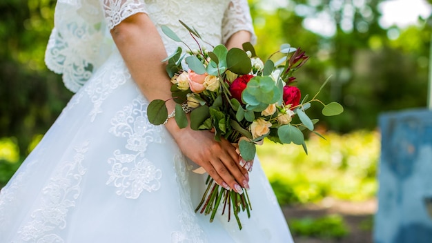 Bouquet entre les mains de la mariée