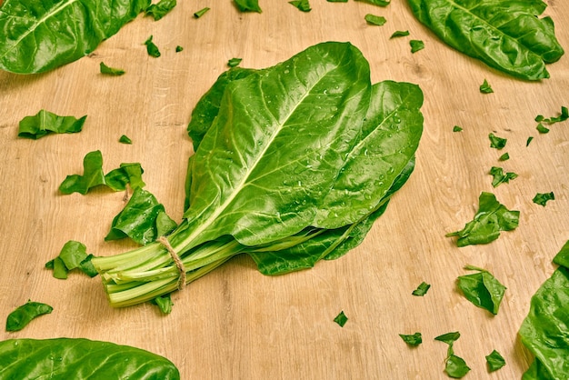 Bouquet d'épinards biologiques frais sur une surface en bois.