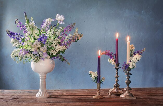 Bouquet d'été avec des bougies allumées sur une surface grise