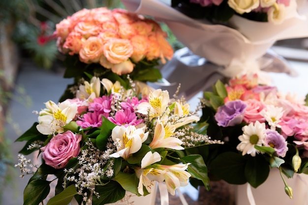 Un bouquet festif de roses et autres fleurs d'été à la lumière du soleil. Fond de fleur