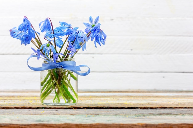 Bouquet de fleur bluebell dans un vase sur la table sur un fond blanc avec espace de copie agrandi