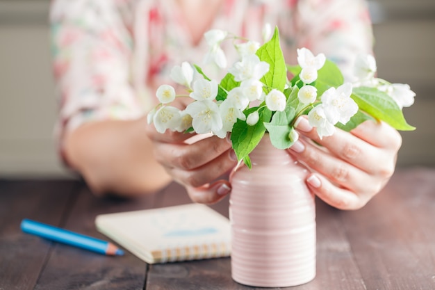 Bouquet de fleurs à l'arrière-plan flou de femme travaillant