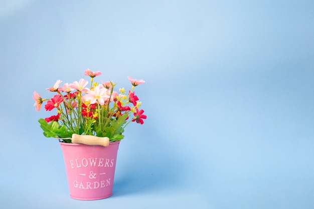 Bouquet de fleurs artificielles en pots roses et fonds bleus