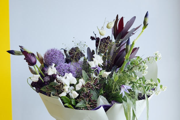 Un bouquet de fleurs bleues et jaunes printanières en livraison chez un fleuriste. Carte postale, vue latérale de mise au point sélective