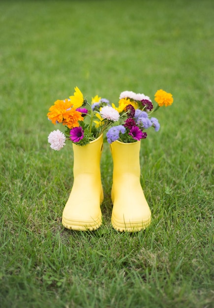 Un bouquet de fleurs en bottes jaunes sur fond d'herbe verte