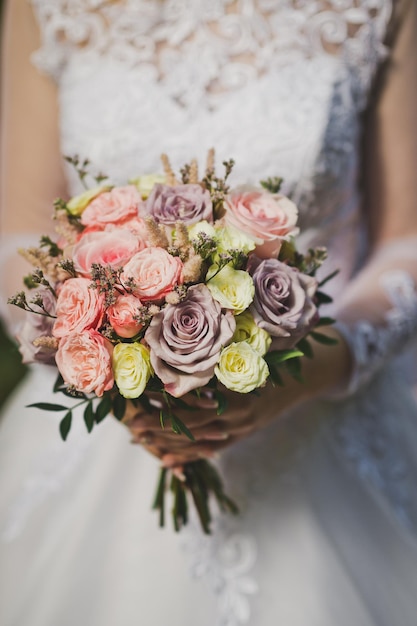 Bouquet de fleurs entre les mains de la mariée dans un mariage ajouré whi