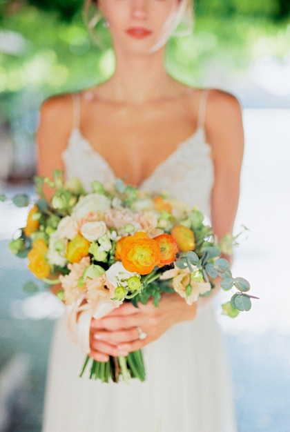 Bouquet de fleurs entre les mains de la mariée