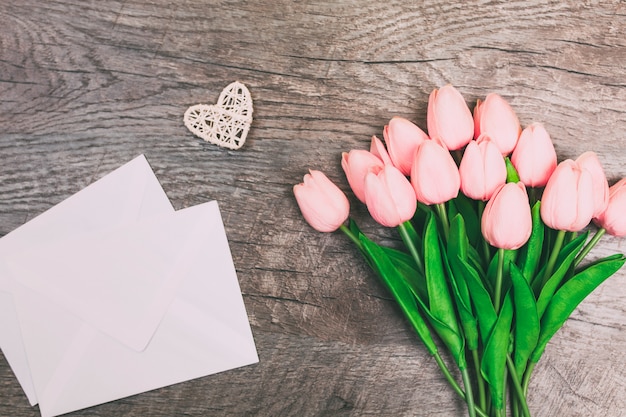 Bouquet de fleurs, enveloppe, sur fond de bois.