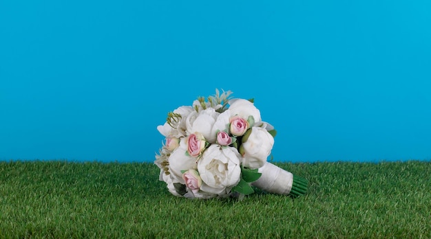 Un bouquet de fleurs est posé sur l'herbe.