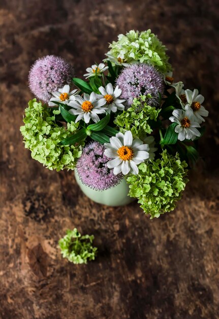 Bouquet de fleurs d'été de marguerites d'hortensias sur une vue de dessus de fond en bois