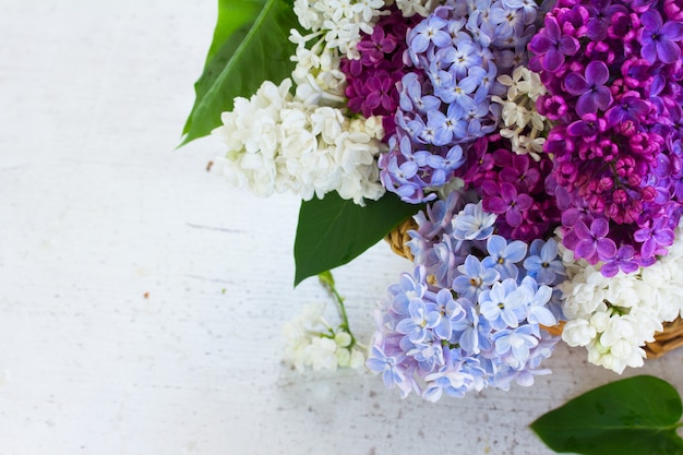 Bouquet de fleurs et de feuilles de lilas frais dans le panier se bouchent