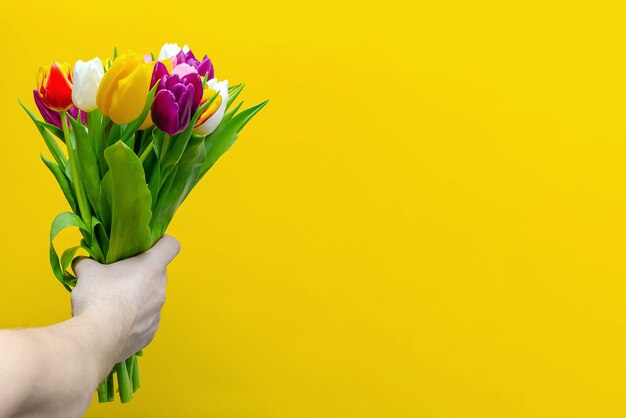 Bouquet de fleurs sur fond jaune. Félicitations pour les vacances, le 8 mars, la Saint-Valentin ou l'anniversaire. Tulipes multicolores.Copy space