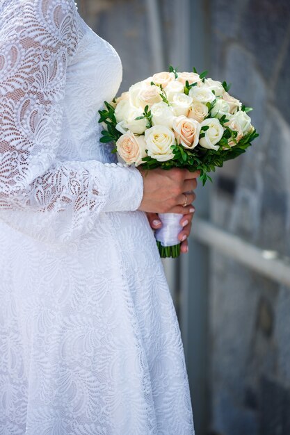 Un bouquet de fleurs fraîches dans les mains de la mariée