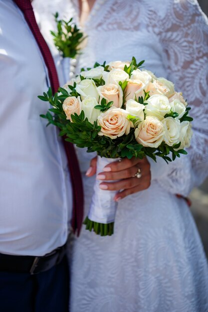 Un bouquet de fleurs fraîches dans les mains de la mariée