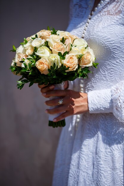 Un bouquet de fleurs fraîches dans les mains de la mariée