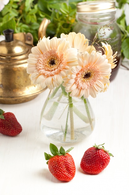 Bouquet de fleurs de gerbera avec assiette de fraises