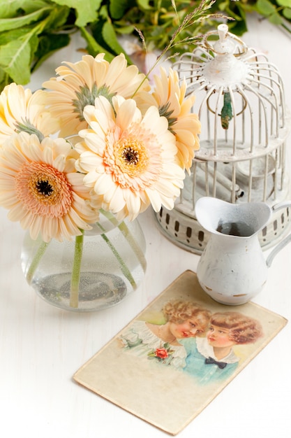 Photo bouquet de fleurs de gerbera avec vieille cage vintage