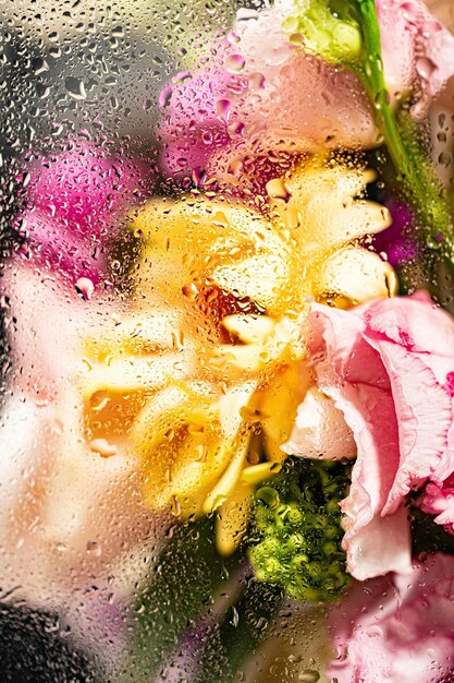 un bouquet de fleurs avec des gouttes d'eau sur le verre