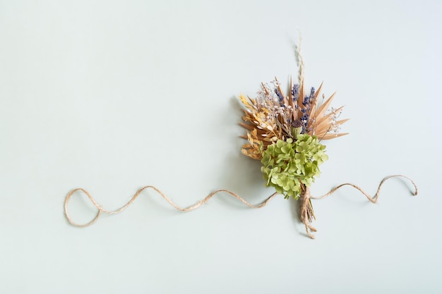 Un bouquet de fleurs et d'herbes sèches sur un fond coloré