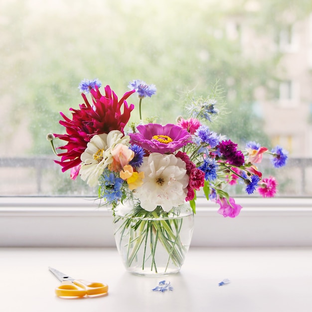 Photo bouquet de fleurs de jardin sur le rebord de la fenêtre