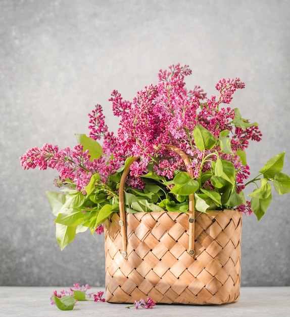 Bouquet de fleurs lilas colorées dans un panier en osier