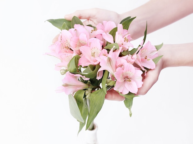 Bouquet de fleurs en mains féminines isolé sur fond clair