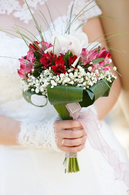 Bouquet de fleurs de mariage dans les mains de la mariée