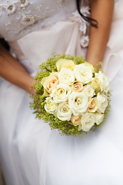 Bouquet de fleurs de mariage dans les mains de la mariée
