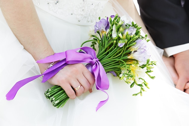 Bouquet de fleurs de mariage dans les mains de la mariée