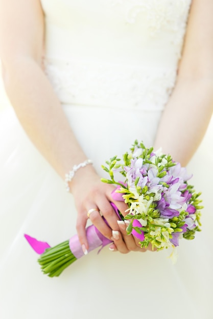 Bouquet de fleurs de mariage dans les mains de la mariée